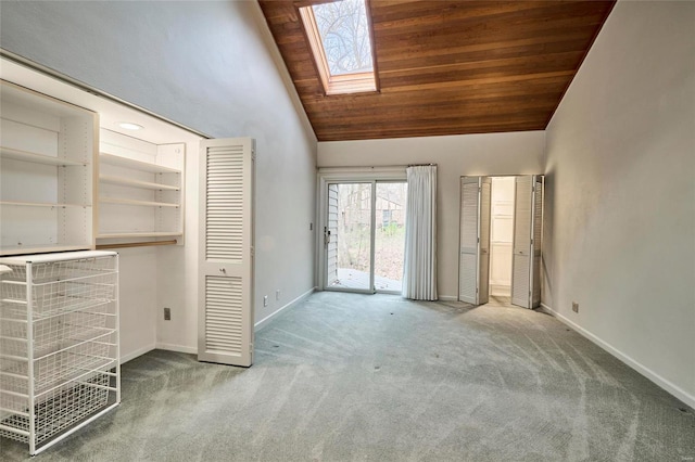 unfurnished bedroom with access to exterior, wooden ceiling, a skylight, and light carpet