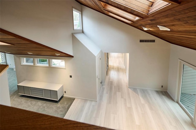 bonus room featuring wood ceiling, light hardwood / wood-style flooring, high vaulted ceiling, and a skylight