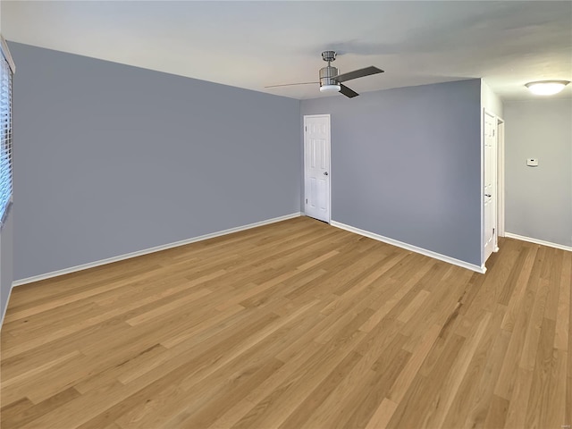 empty room with ceiling fan and light hardwood / wood-style flooring