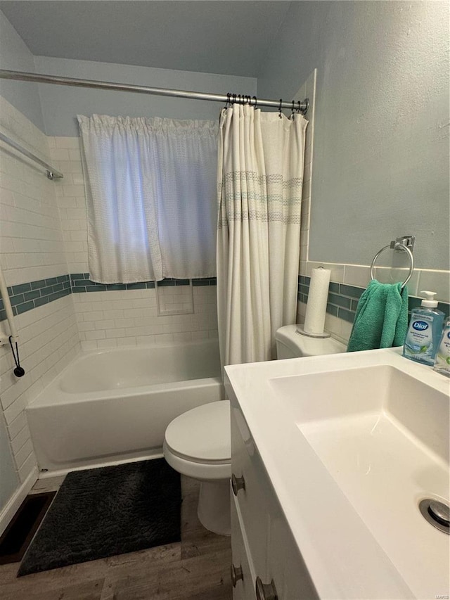 full bathroom with hardwood / wood-style floors, toilet, shower / bathtub combination with curtain, and sink