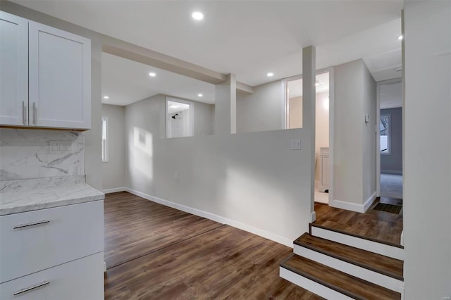 interior space with light stone countertops, decorative backsplash, dark hardwood / wood-style flooring, and white cabinetry