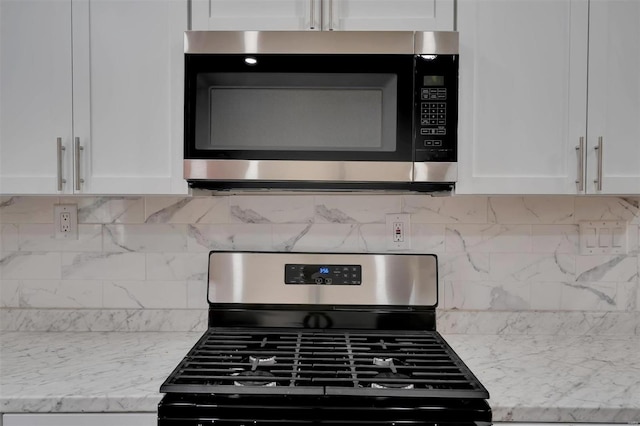 details featuring white cabinets, appliances with stainless steel finishes, tasteful backsplash, and light stone countertops