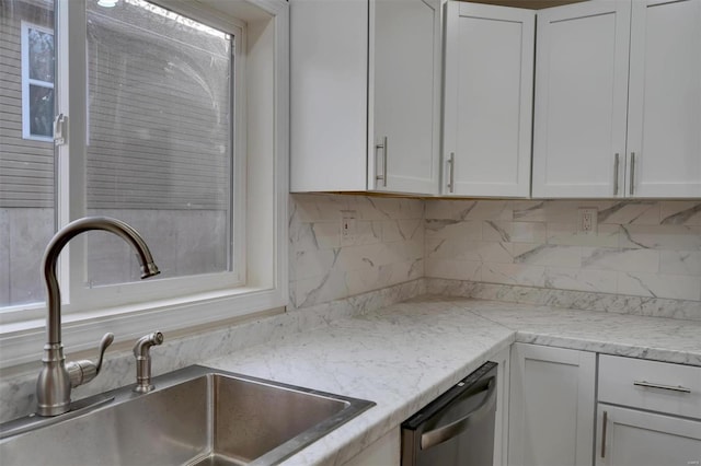 kitchen featuring white cabinets, stainless steel dishwasher, and sink