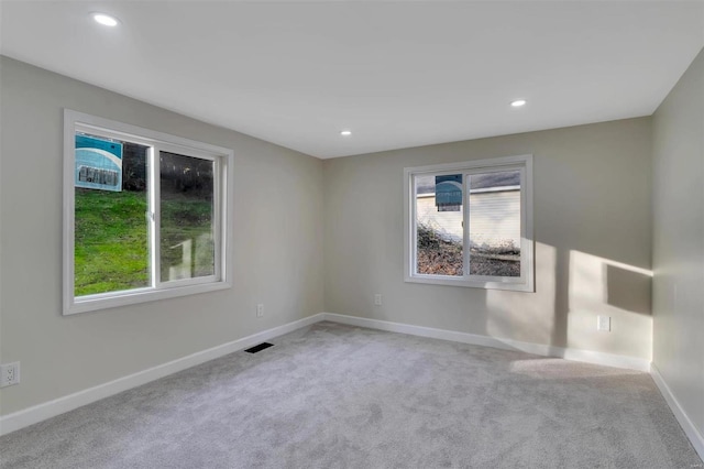 unfurnished room featuring light carpet