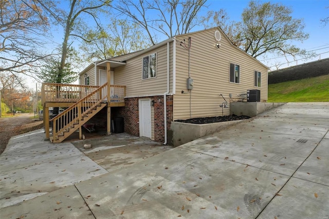 view of side of home with central air condition unit and a wooden deck