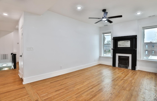 unfurnished living room featuring ceiling fan and light hardwood / wood-style floors