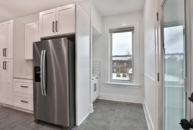 kitchen featuring white cabinetry and stainless steel fridge