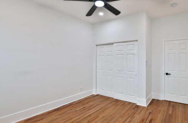 unfurnished bedroom featuring hardwood / wood-style flooring, ceiling fan, and a closet