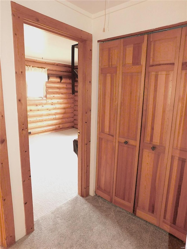 corridor featuring log walls and light colored carpet