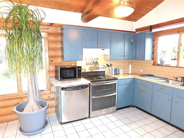 kitchen with sink, vaulted ceiling with beams, blue cabinetry, rustic walls, and stainless steel appliances