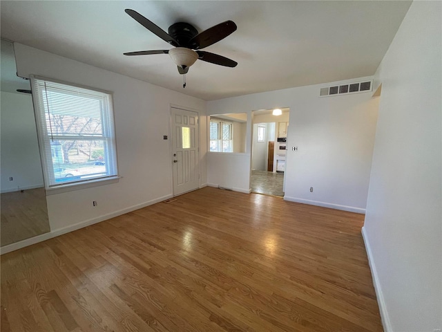 unfurnished living room featuring light hardwood / wood-style floors, ceiling fan, and a healthy amount of sunlight