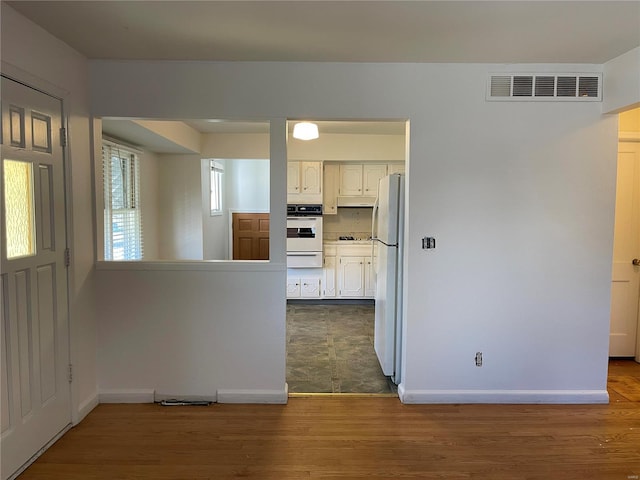 kitchen featuring white cabinets, white appliances, and dark hardwood / wood-style floors