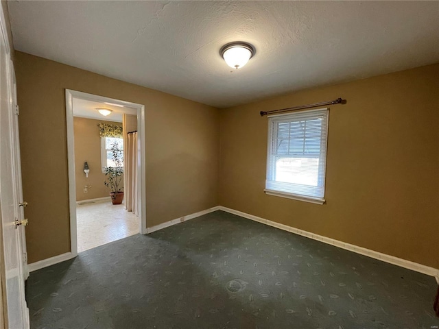 empty room featuring a textured ceiling and plenty of natural light