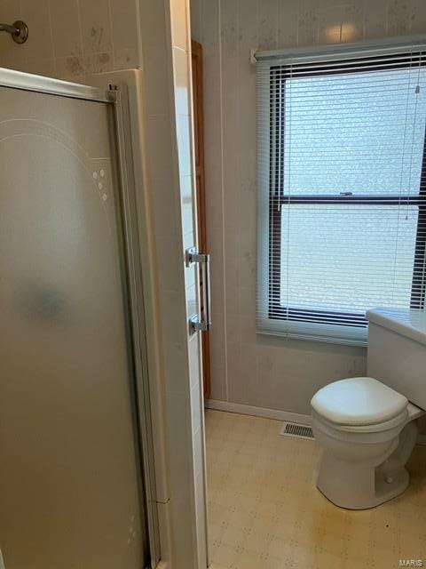 bathroom featuring toilet and walk in shower