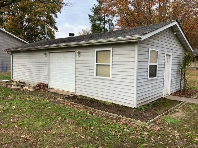 view of home's exterior featuring an outbuilding, a garage, and a lawn