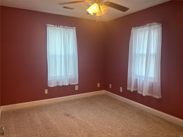 spare room with carpet floors, ceiling fan, and a healthy amount of sunlight