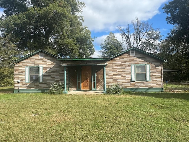 rear view of house featuring a yard and a carport