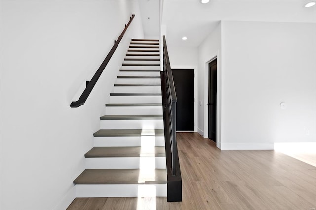 stairs featuring hardwood / wood-style floors