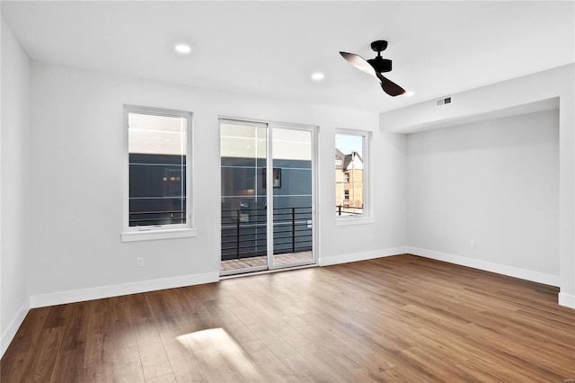 spare room featuring ceiling fan, plenty of natural light, and wood-type flooring