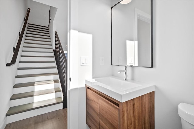 bathroom featuring vanity, wood-type flooring, and toilet