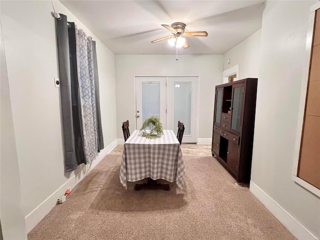 carpeted dining space with ceiling fan