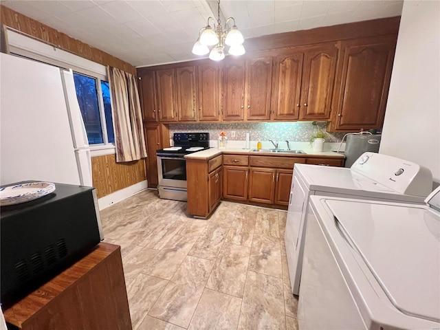 kitchen with pendant lighting, white refrigerator, a notable chandelier, independent washer and dryer, and stainless steel electric range