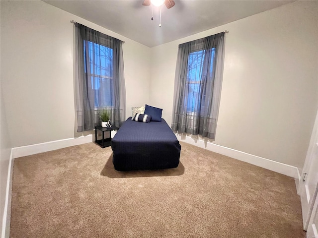 carpeted bedroom with multiple windows and ceiling fan