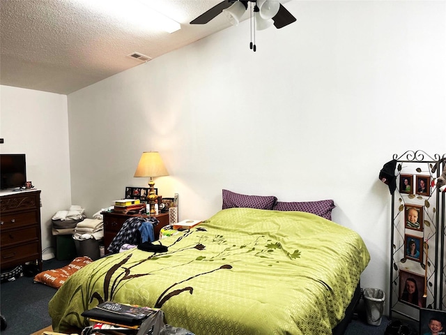 bedroom featuring carpet flooring, ceiling fan, and a textured ceiling