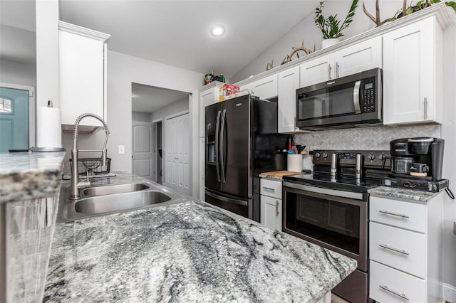 kitchen with white cabinetry, sink, lofted ceiling, decorative backsplash, and appliances with stainless steel finishes