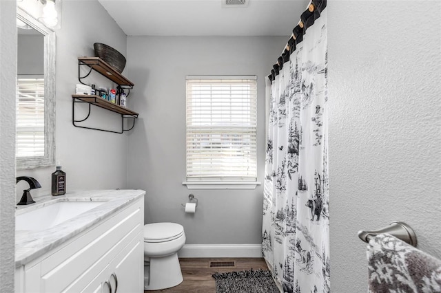 bathroom with a shower with curtain, vanity, hardwood / wood-style flooring, and toilet