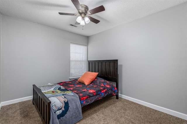 carpeted bedroom with ceiling fan and a textured ceiling