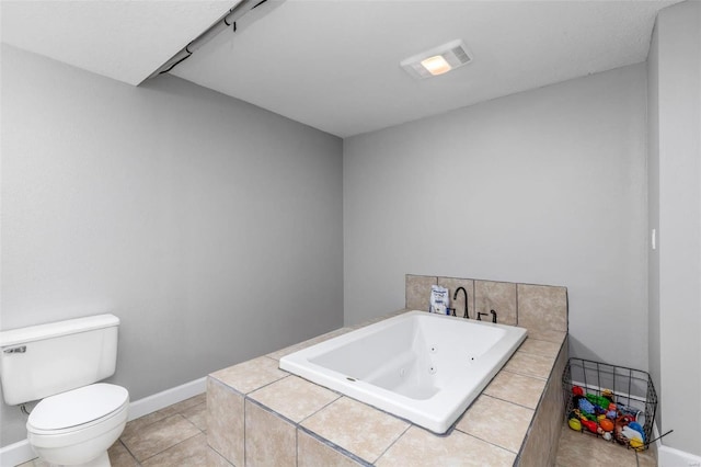 bathroom featuring tile patterned flooring, toilet, and a tub