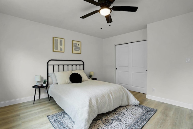 bedroom featuring light wood-type flooring, a closet, and ceiling fan