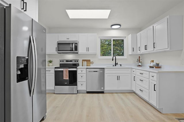 kitchen featuring white cabinets, appliances with stainless steel finishes, and light wood-type flooring