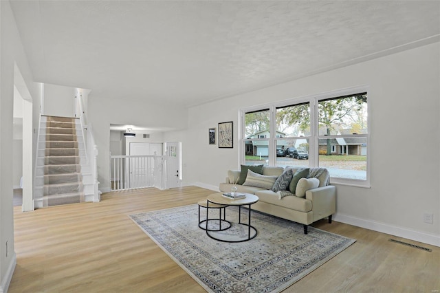 living room with a textured ceiling and light hardwood / wood-style flooring