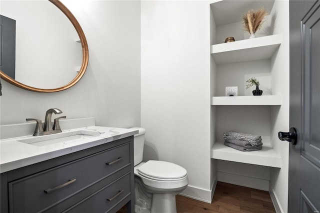 bathroom featuring wood-type flooring, vanity, and toilet