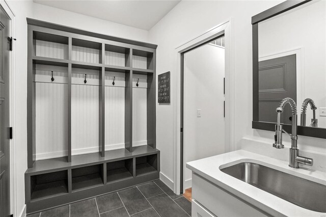 mudroom with dark tile patterned floors and sink