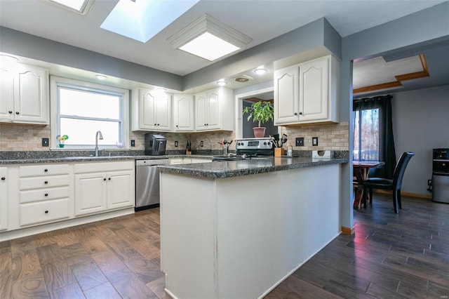 kitchen with backsplash, white cabinetry, dark wood-type flooring, and appliances with stainless steel finishes