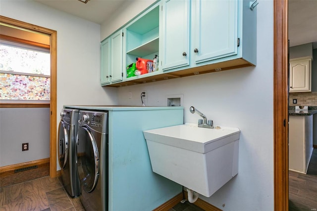 washroom with cabinets, dark hardwood / wood-style flooring, washer and clothes dryer, and sink