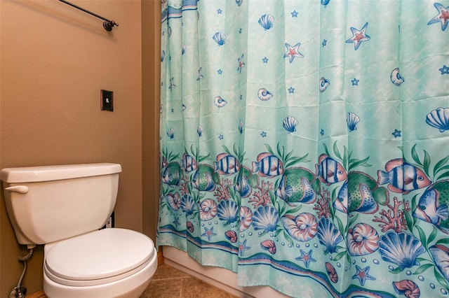 bathroom with toilet, a shower with curtain, and tile patterned floors