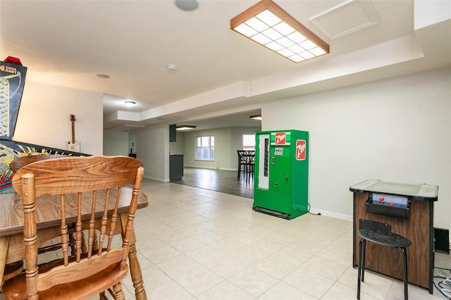 interior space featuring light tile patterned floors and a tray ceiling