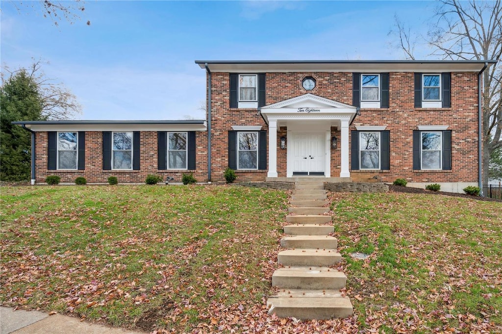 colonial home with a front lawn