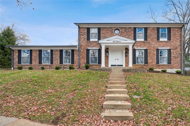 colonial inspired home with a front lawn