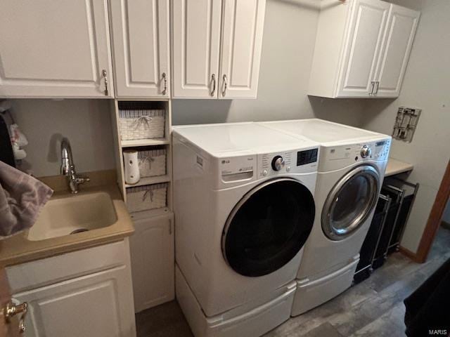 laundry room featuring dark hardwood / wood-style flooring, sink, cabinets, and independent washer and dryer