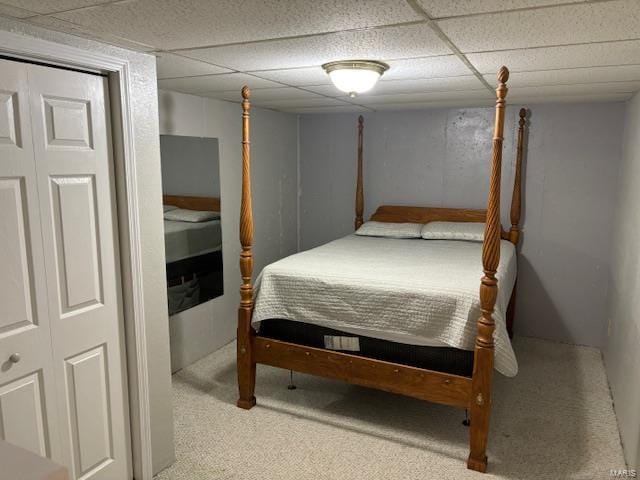 bedroom featuring light carpet and a paneled ceiling