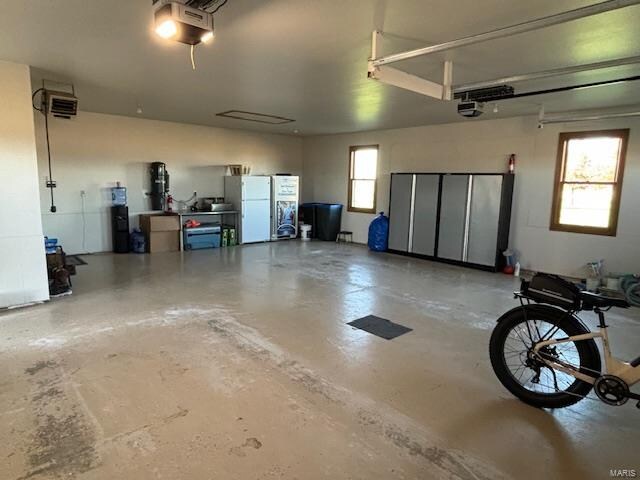 garage featuring white refrigerator and a garage door opener