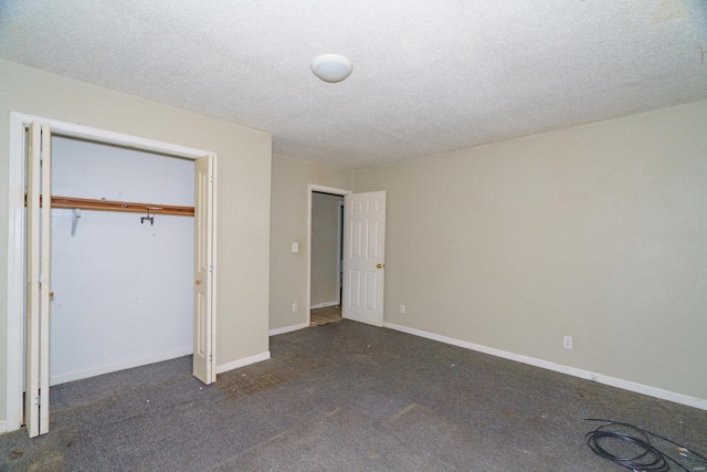 unfurnished bedroom featuring a closet, a textured ceiling, and dark colored carpet