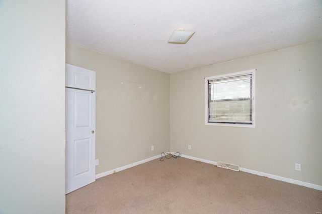 carpeted spare room with a textured ceiling