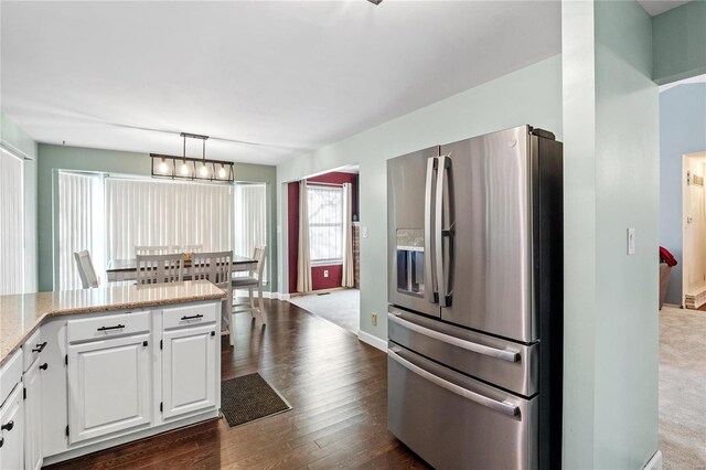 kitchen featuring pendant lighting, an inviting chandelier, stainless steel fridge with ice dispenser, dark hardwood / wood-style flooring, and white cabinetry