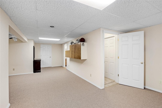 basement featuring a drop ceiling and carpet